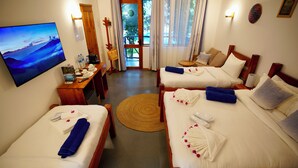 A hotel room with two beds, a TV, a desk with a chair, and a view of the outdoors. - Oasis Nungwi (Nungwi)
