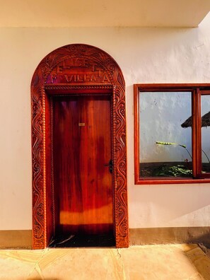 Una puerta de madera con tallas intrincadas y el nombre 'FAMILY A' en la parte superior.