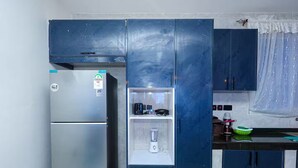 A kitchen with a refrigerator, a built-in microwave, and a water dispenser. - Homes by Pesh - Nyali, 2 bedroom - Mombasa. (el doret)