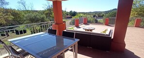 En balkon med et glasbord og grillområde.