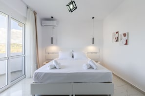 Ein modernes Hotelzimmer mit einem großen Bett, zwei Nachttischen, einem Fenster mit Vorhängen und einem Bild an der Wand.