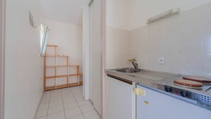 Eine Küche mit Spüle, Herd und einer Holzregaleinheit.