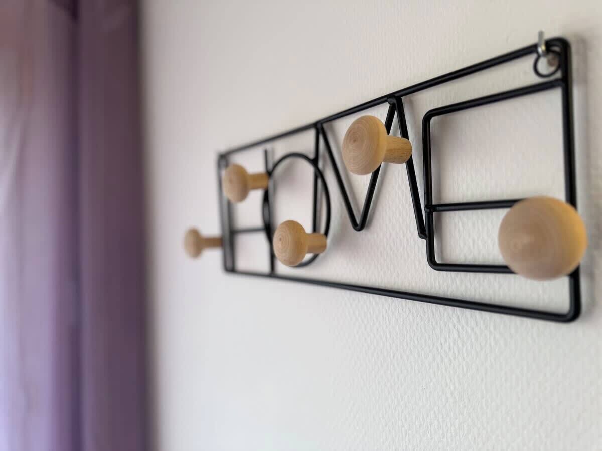 A wall-mounted decoration with the word "LOVE" spelled out in letters, each letter having a wooden knob.