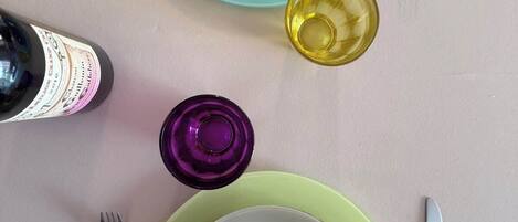 A table set with plates, cutlery, and a bottle of wine.