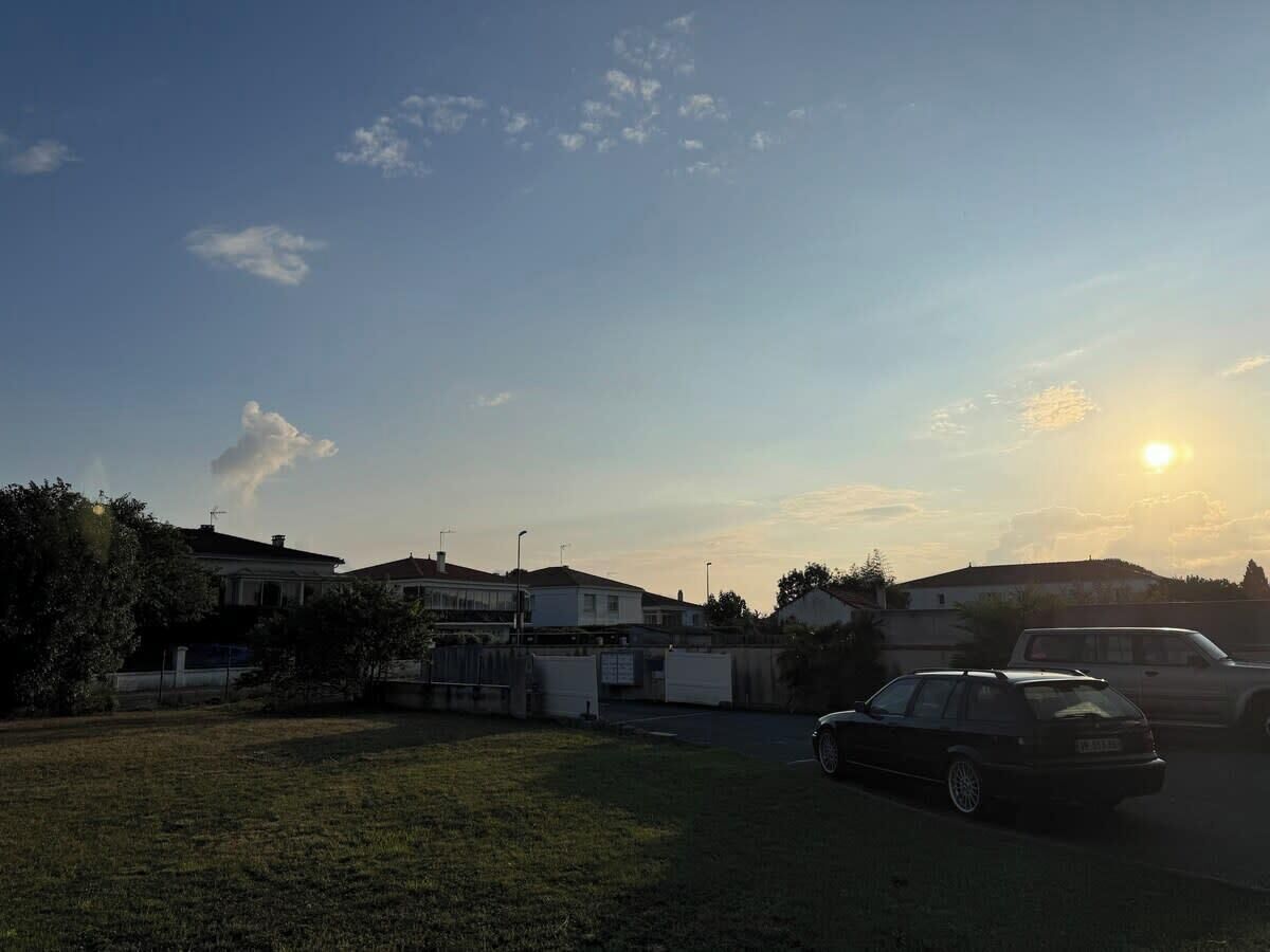 A residential area with houses, a parking lot, and a car.