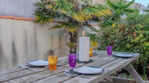 A wooden picnic table set outdoors with plates, cutlery, and glasses. - Dunes Apart-Hotel - Kiwi Residence (Aytré)