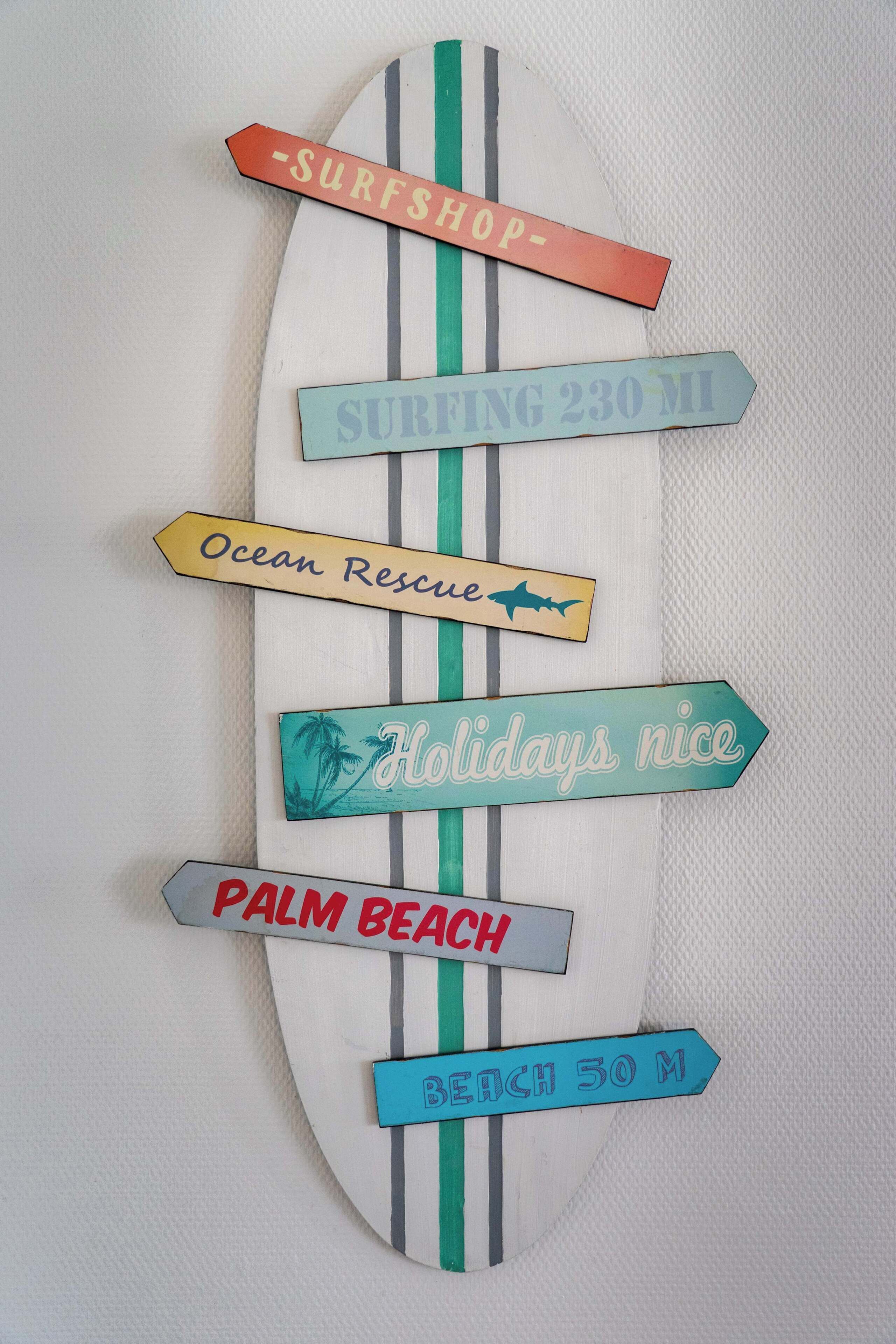 A surfboard-shaped sign with directional labels.