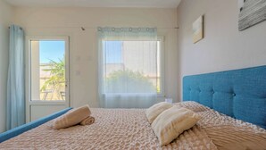 Une chambre à coucher avec un lit, une fenêtre et une vue sur l’extérieur.