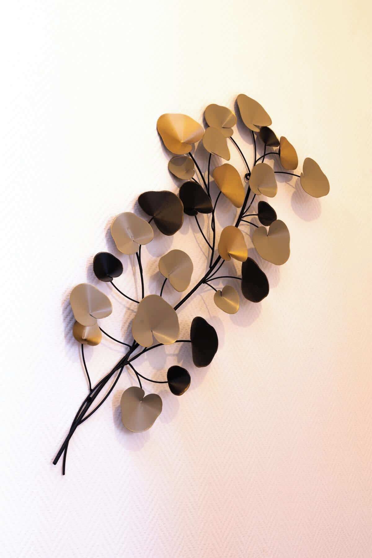 Un élément décoratif à fixer au mur, composé d’éléments en forme de cœur dans des tons de beige et de noir, reliés par de fines lignes noires.