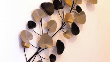 Un élément décoratif à fixer au mur, composé d’éléments en forme de cœur dans des tons de beige et de noir, reliés par de fines lignes noires.