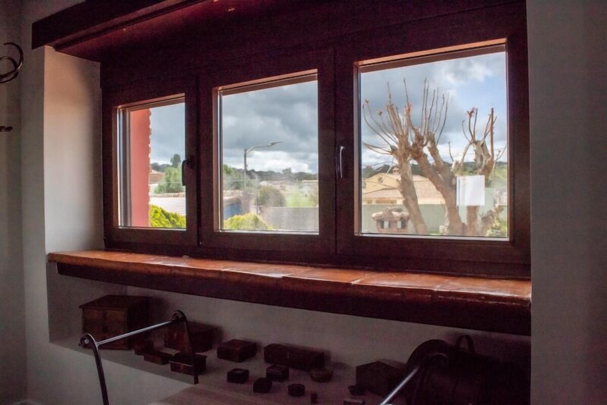 A window with a view of a tree and a building.
