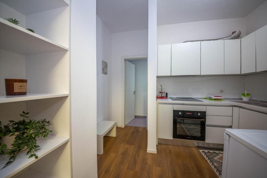 A compact kitchen with white cabinets, a built-in oven, and a small countertop.