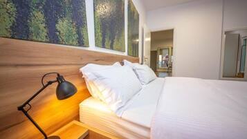 Un dormitorio moderno con cabecera de madera, lámpara de noche, cama bien hecha y grandes cuadros abstractos en la pared.