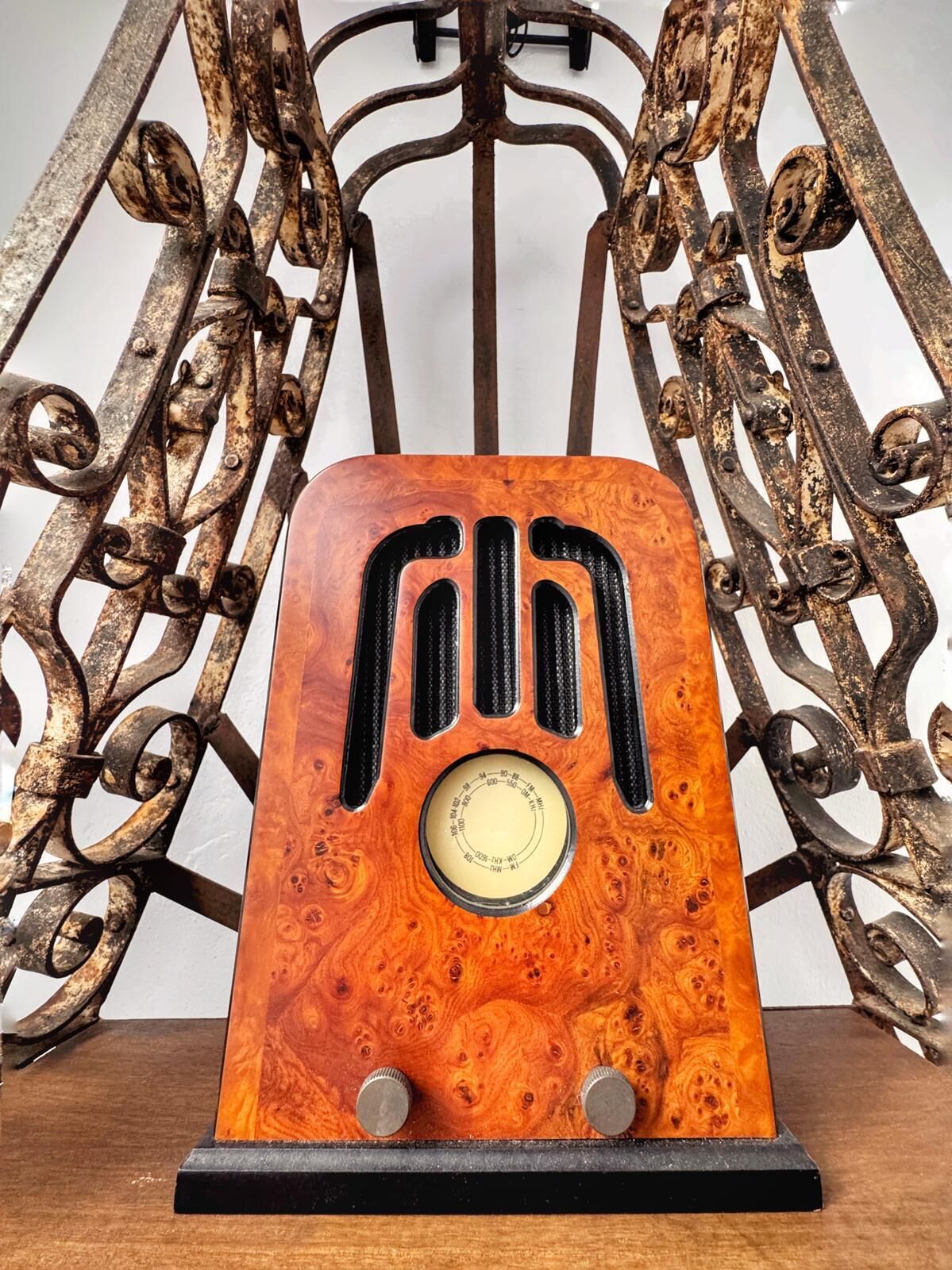 Una radio antigua con detalles de madera y un dial circular, sobre un soporte negro.