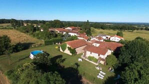 A residential area with multiple houses, a swimming pool, and a grassy lawn.