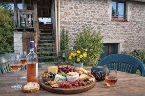A wooden table with a charcuterie board, wine glasses, and a bottle of rosé wine.