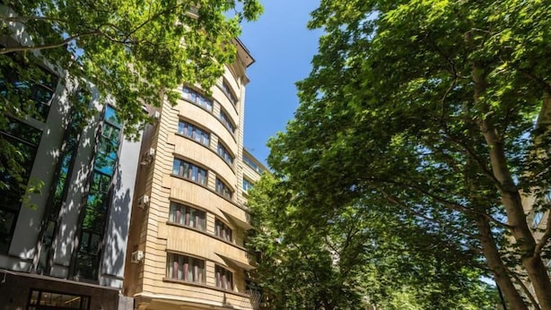 Un hôtel à plusieurs étages, doté d’une façade incurvée, de grandes fenêtres et d’une entrée centrale avec un escalier.
