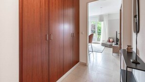 A hallway with wooden wardrobes, a modern kitchen area, and a view of a balcony with outdoor seating. - Studio 4* with balcony and parking in Bel Air (Luxembourg)