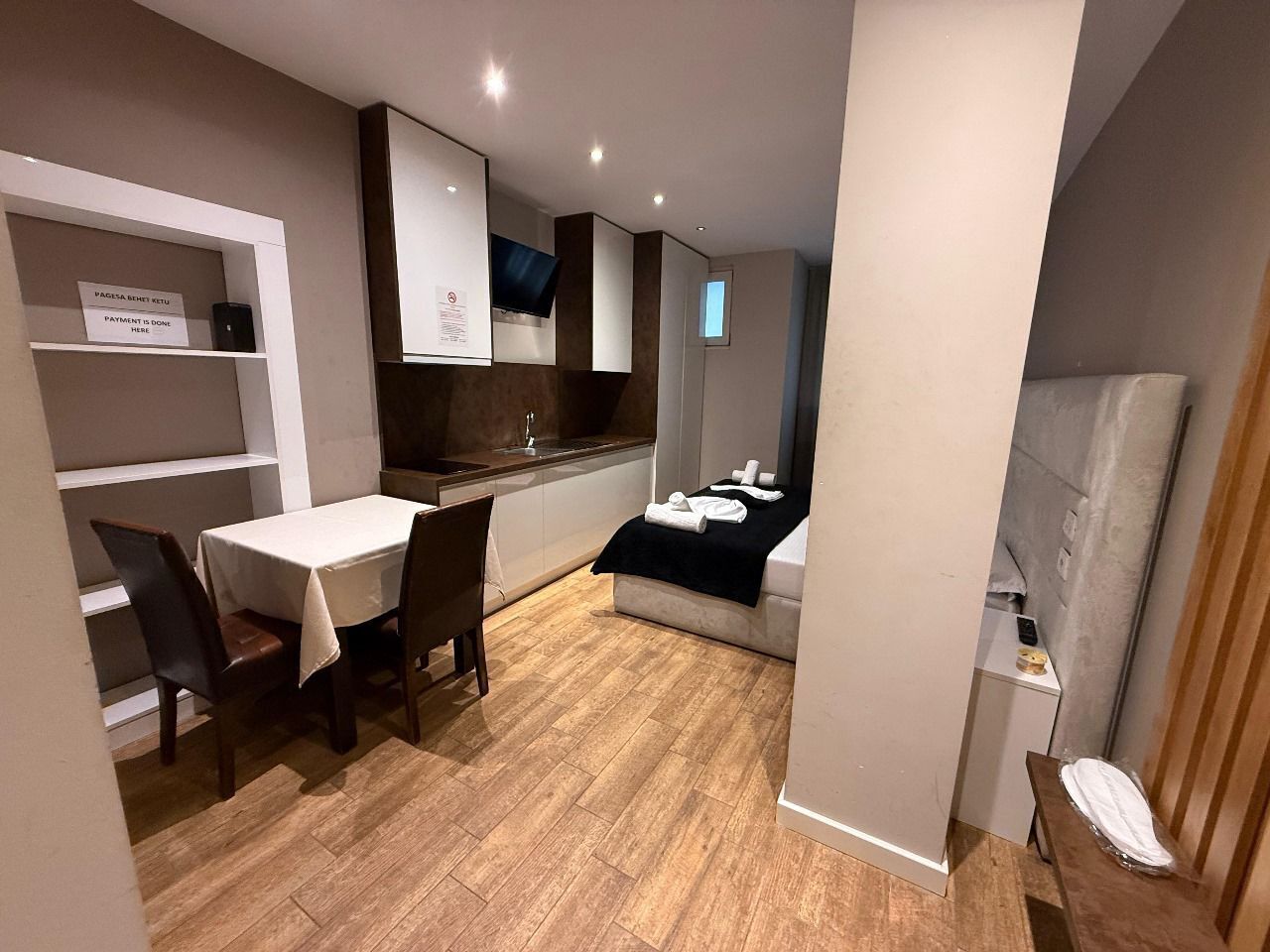 A compact kitchen with a dining area, a bed, and a small seating area.