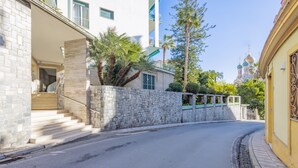 A street with stone walls, a staircase, and a building with a balcony. - Sanremo Belle Epoque Apartment by Wonderful Italy (Sanremo)
