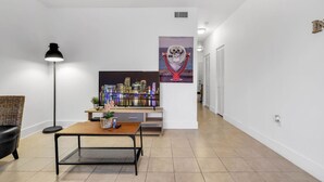 Ein modernes Wohnzimmer mit Sofa, Couchtisch, Stehlampe und einem Stadtbild an der Wand.