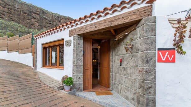 A building with a stone facade, a wooden door, and a tiled entrance. - Vacation Apartment 'Casa Rural Ruta Del Tajinaste Azul' with Sea View, Wi-Fi & Air Conditioning (Valsequillo)