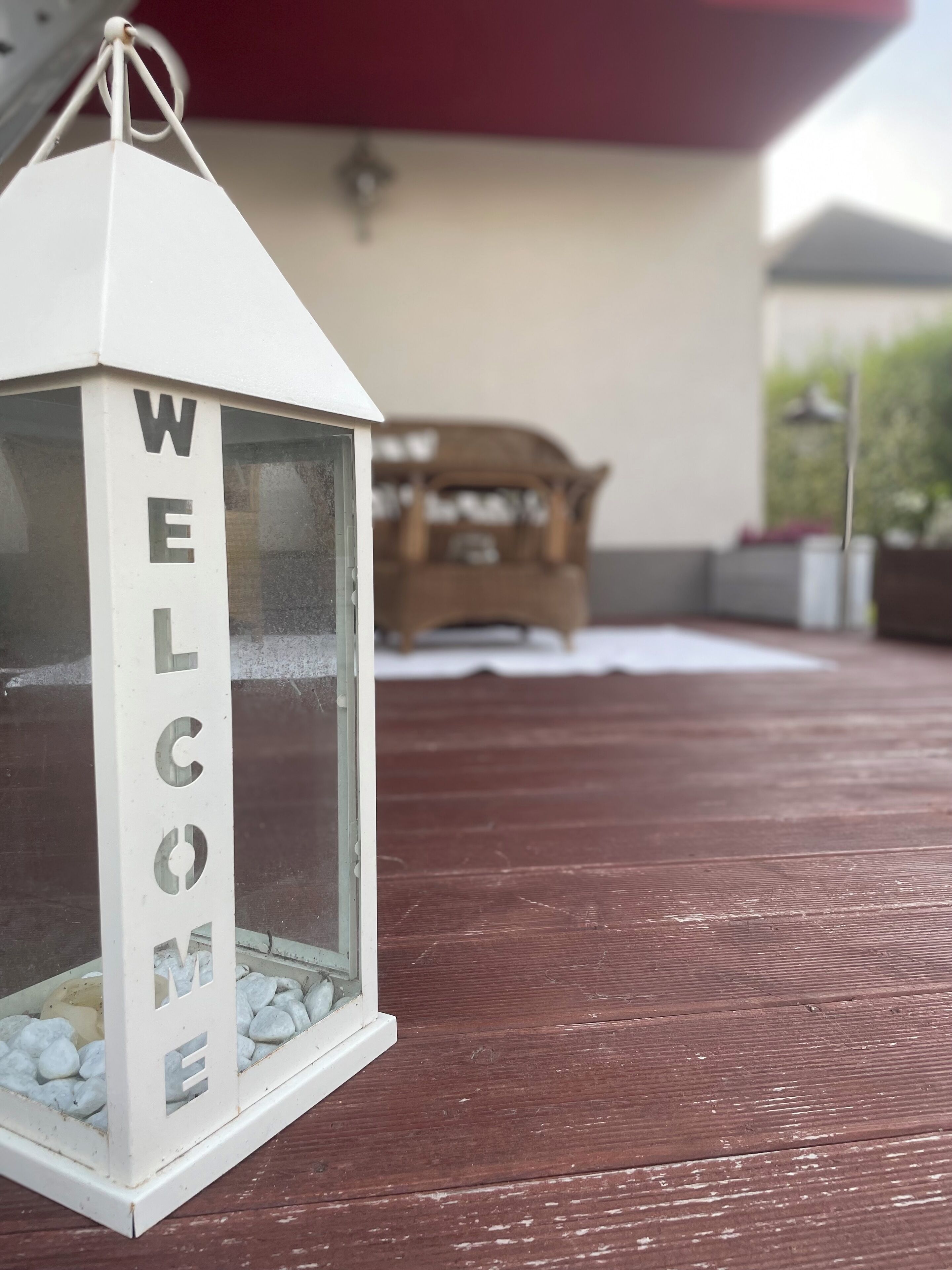 Una lanterna bianca con la scritta “WELCOME” su un pontile di legno.