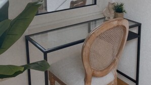 Un bureau d’angle avec une chaise, une petite plante et un miroir.