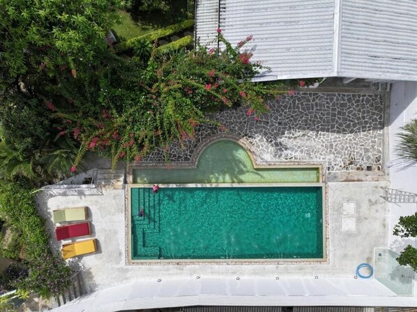 An aerial view of a hotel with a swimming pool, surrounded by lush greenery and a stone pathway. - Hebron Gardens House  (Kandy)