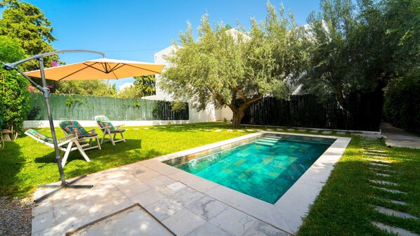 A rectangular swimming pool with clear blue water, surrounded by a well-maintained lawn and a tree. - Residence Jannet 1 Luxury Seaside 3 Bedrooms (Hammamet)