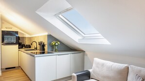 Een moderne keuken met dakraam, witte kasten en een klein eiland.