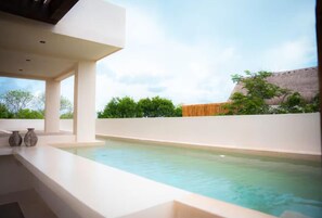 Un espace piscine extérieur moderne offrant une vue dégagée sur le ciel et la végétation environnante.