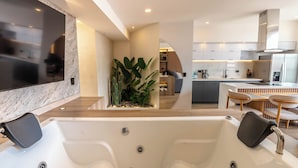 A modern kitchen with a central island, built-in appliances, and a seating area with a dining table and chairs. - Hotel Time Oclock (Medellín)