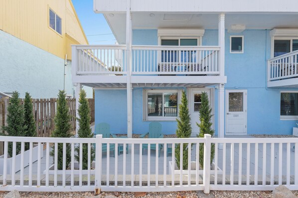 A two-story building with a white balcony and a door marked 1005. - 🏖️Incredible Location | Pet Friendly | Steps to Beach | Villa Bleu 2🏖️ (New Smyrna Beach)