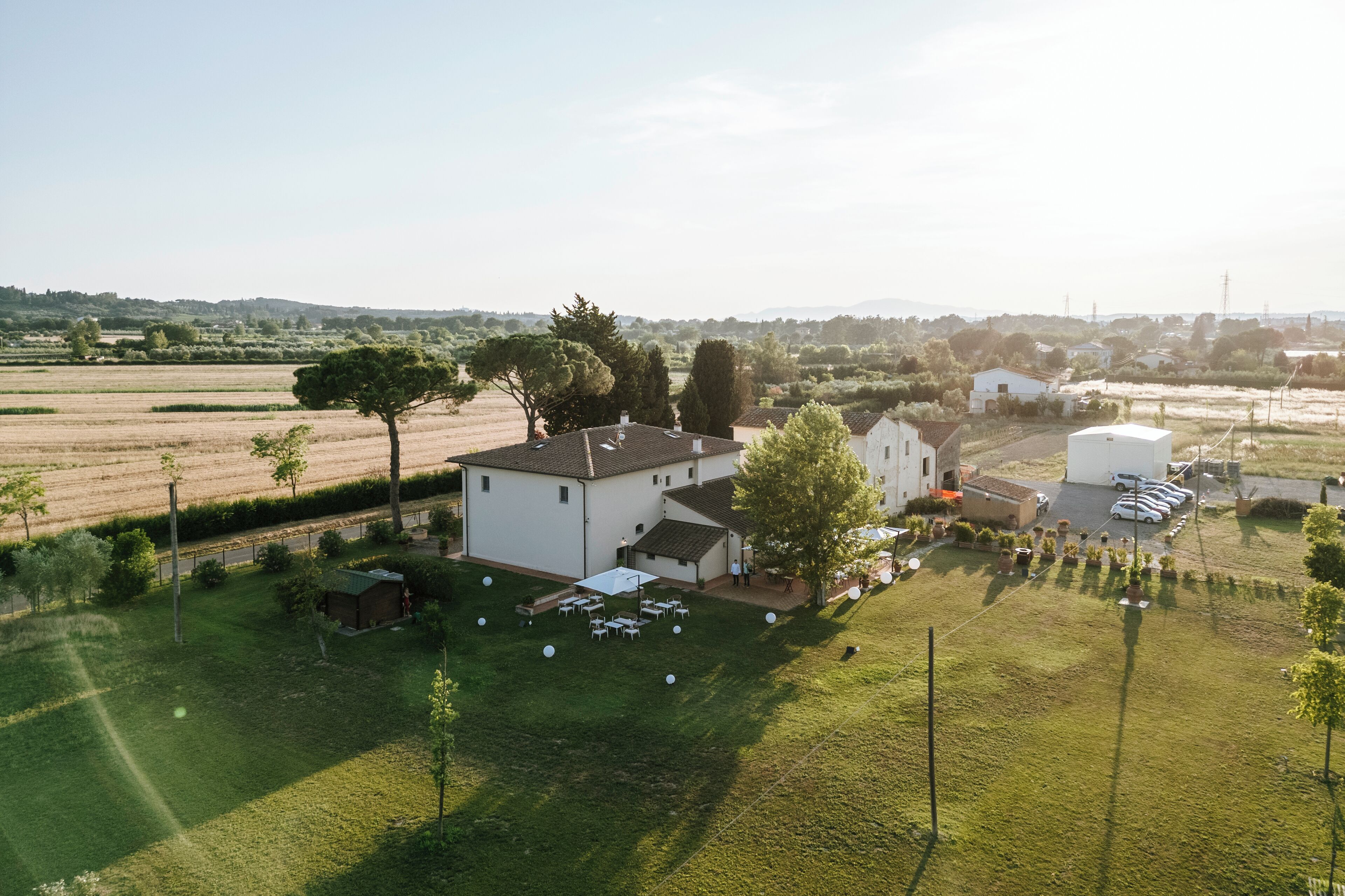 Vista aérea de una zona residencial con casas, un campo cubierto de hierba y coches aparcados.
