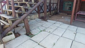 A staircase leading to a wooden deck area with a small table and a window with green shutters. - Fresh breeze.  In front of the sea (Barra Velha)