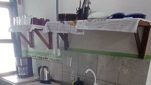A compact kitchen with a sink, a kettle, and a green plastic container on the counter. - Fresh breeze.  In front of the sea (Barra Velha)
