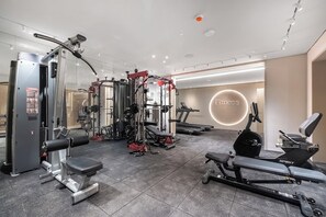 A gym with various exercise equipment, including a bench press, a rowing machine, and weight machines. - Eilat Bay Retreat • Sea Views by SeaNRent (Eilat)