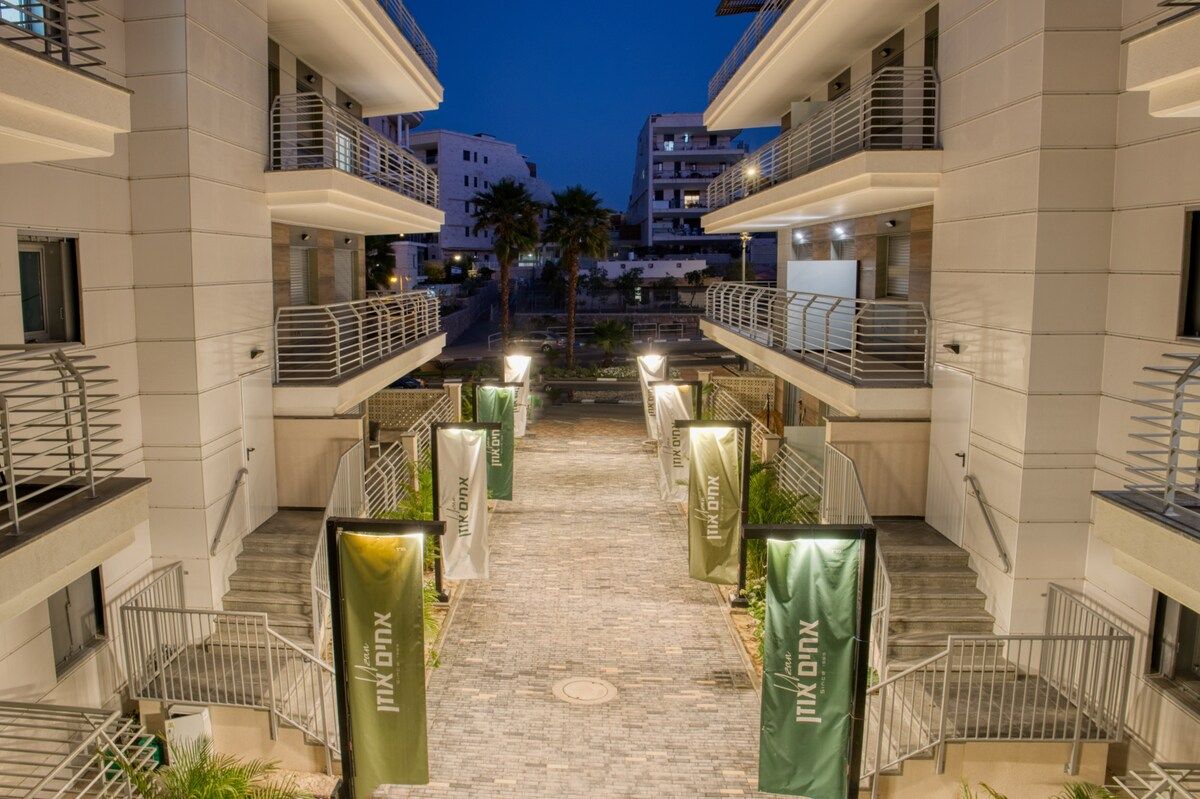 A multi-level hotel corridor with a central pathway flanked by balconies and staircases.