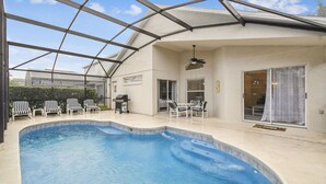 A swimming pool with lounge chairs and a covered patio area. - 4BR Lake Berkley Home, Pool & Game Room (Kissimmee)