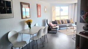 Een moderne woonkamer met een eethoek, een bank en een salontafel.