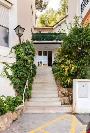 A staircase leading to a building entrance, surrounded by greenery and a lamp post. - Apartment 'Sea View' with Ocean Views, Wi-Fi, and Air Conditioning (Torremolinos)