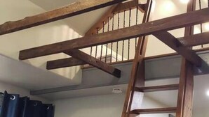A room with a wooden ceiling beam structure, a ceiling fan, a wooden ladder, a dresser, and a door. - Extended Loft. Near AT, C&O, Harper`s Ferry (Brunswick)
