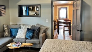 A cozy living room with a sofa, a coffee table, and a dining area with a table and chairs. - Extended Loft. Near AT, C&O, Harper`s Ferry (Brunswick)