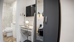 Ein Badezimmer mit Toilette, Waschbecken mit Spiegel und Duschbereich.