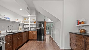 A modern kitchen with wooden cabinets, a black refrigerator, and a wooden countertop. - The Franklin House, Home for 6 (Franklin)