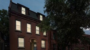A two-story brick building with large windows and a central entrance. - Modern Soulard • WiFi • Laundry • Queen • Menard (St. Louis)