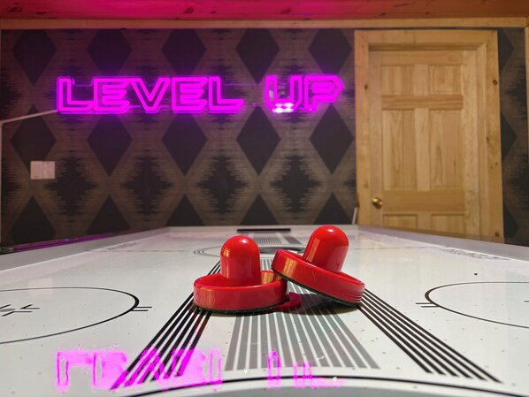 Une table avec, en arrière-plan, un panneau lumineux au néon sur lequel on peut lire « LEVEL UP ».