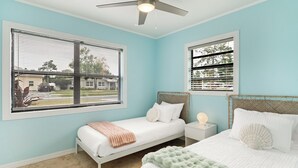 A bedroom with a bed, a nightstand, a ceiling fan, and two windows with blinds. - Private Pool & Grill ~ 8 Min to Beach ~ Pets Welcome ~ Near Clearwater Beach (Largo)