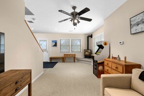 Un salon doté d’un ventilateur de plafond, d’une cheminée, d’un banc et d’un canapé.